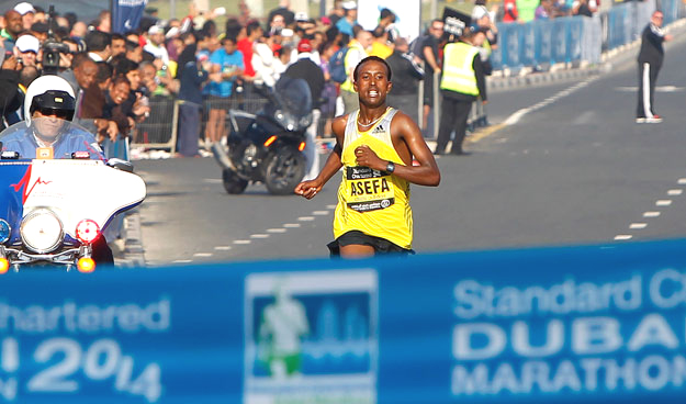 Tsegaye Mekonnen Asefa of Ethiopia, touching the finishing line during the Standard Chartered Dubai Marathon at Umm Suqeim Road in Dubai on Friday,  January 24, 2014. KT photo by Juidin Bernarrd